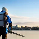 Kvinna åker skridskor på isen med Luleå stad i bakgrunden